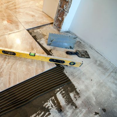 Setting large floor tiles in a living area with level tools