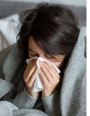 Woman resting at home with cold and flu symptoms, representing when self-treatment may no longer be enough before seeing a GP