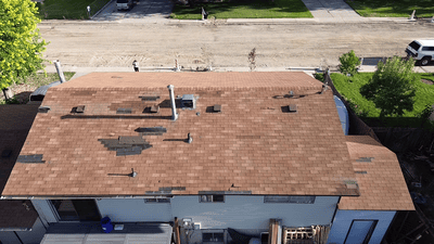 Close-up aerial shot of a residential roof with missing shingles