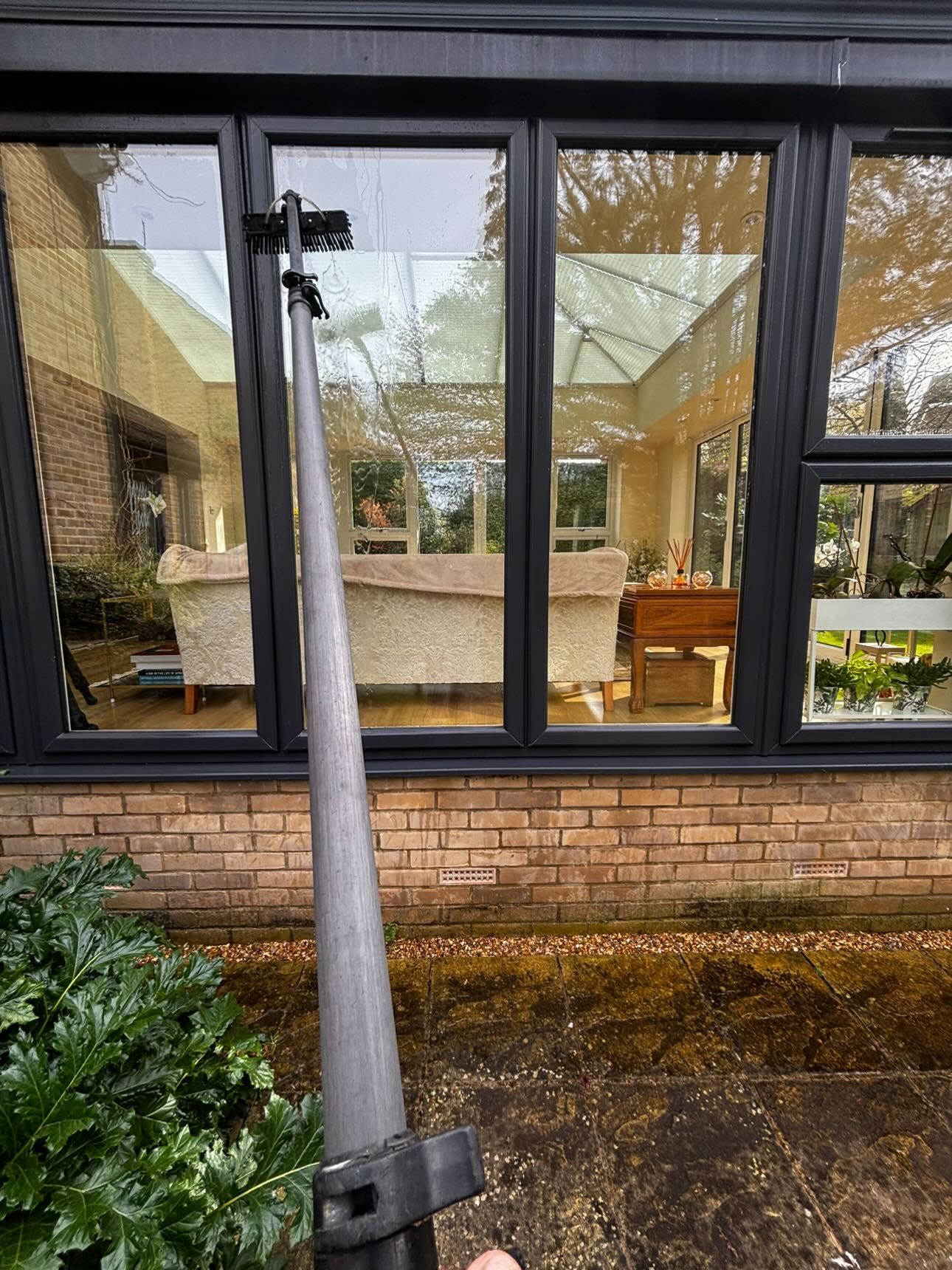First person cleaning a large house window