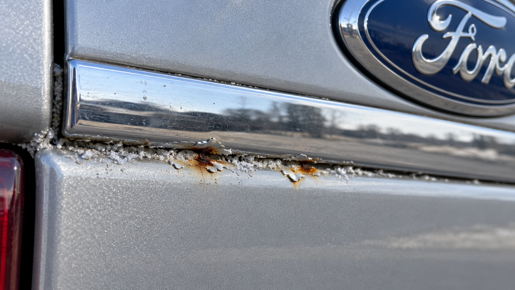 Early salt corrosion lifting paint at a body seam