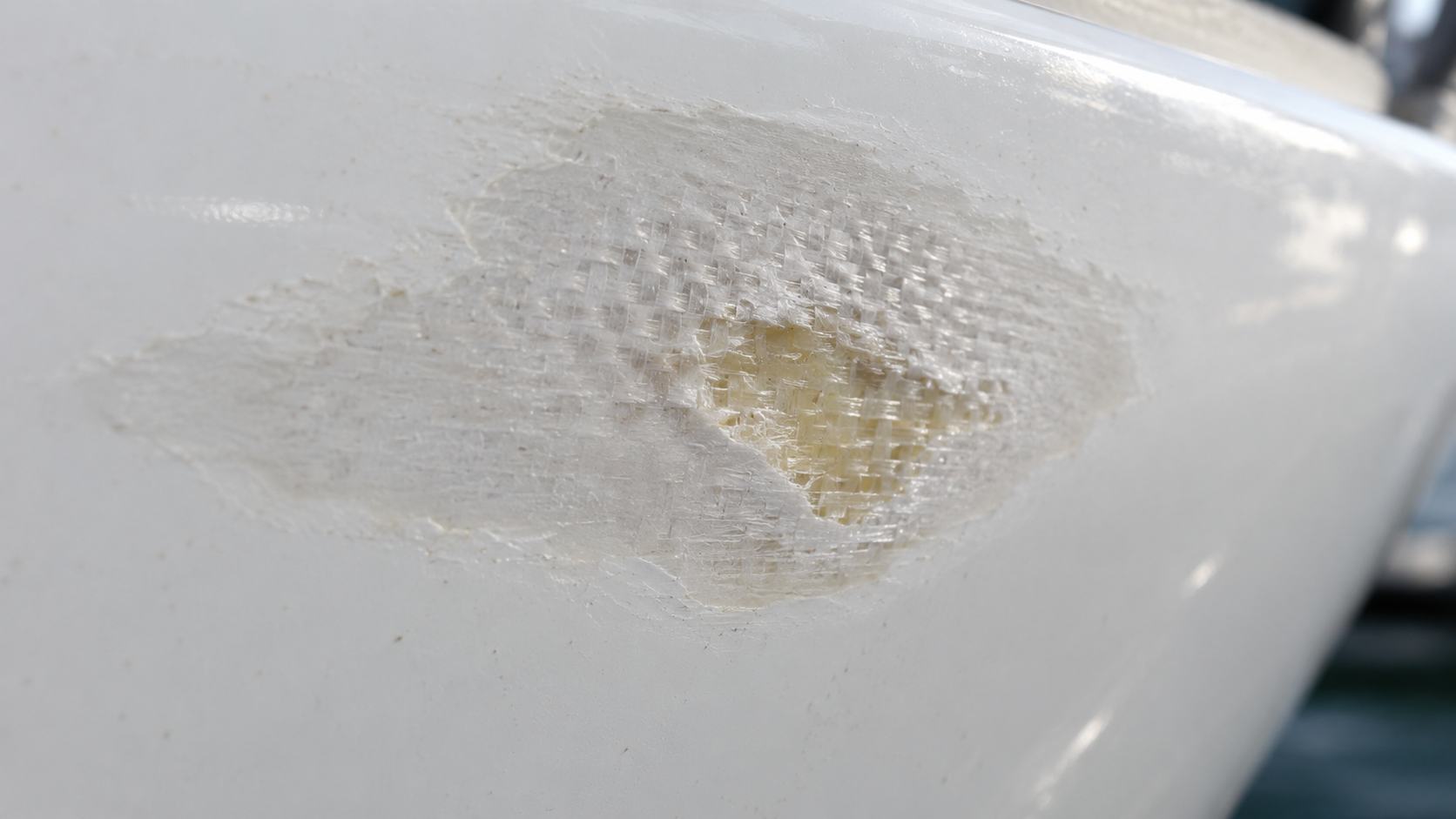Gelcoat worn through to show the fibreglass laminate underneath