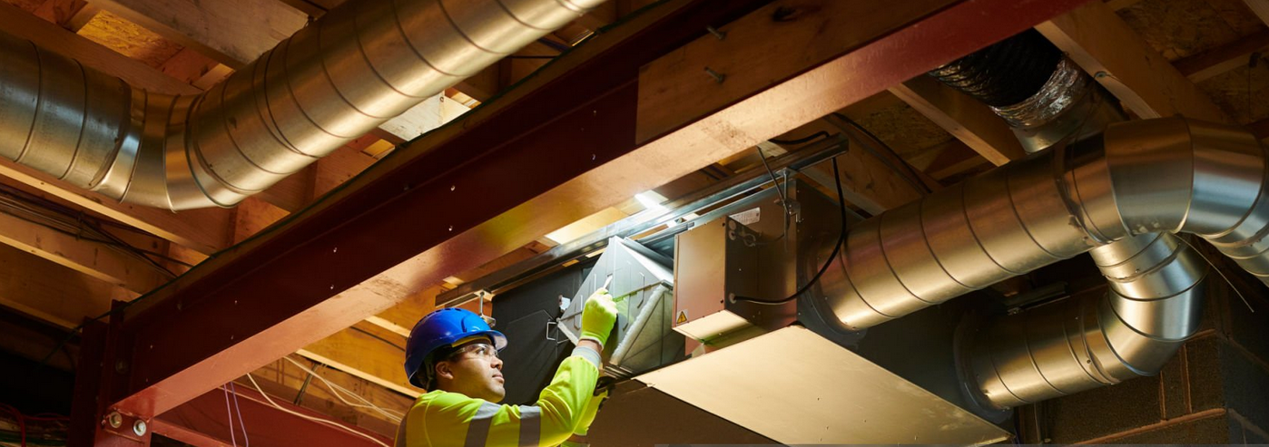 HVAC technician inspecting ductwork