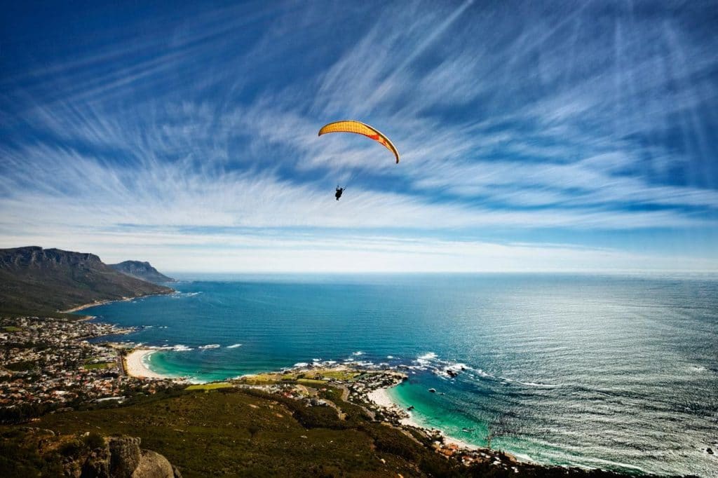 Paragliding over Cape Town with ocean and mountain views.