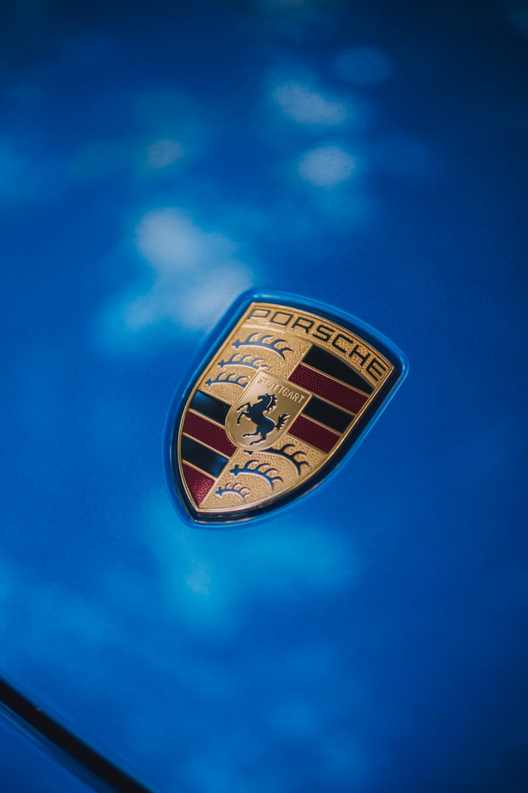 Close-up of the Porsche badge on the blue bonnet.