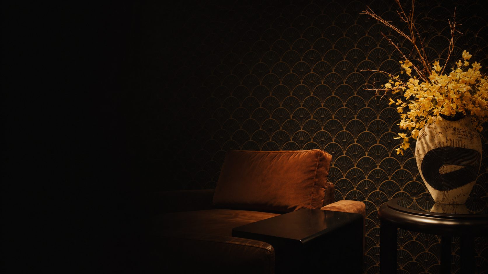 Dark luxury lounge corner with art deco wallpaper, amber flowers, leather seating and warm premium lighting fading into black.