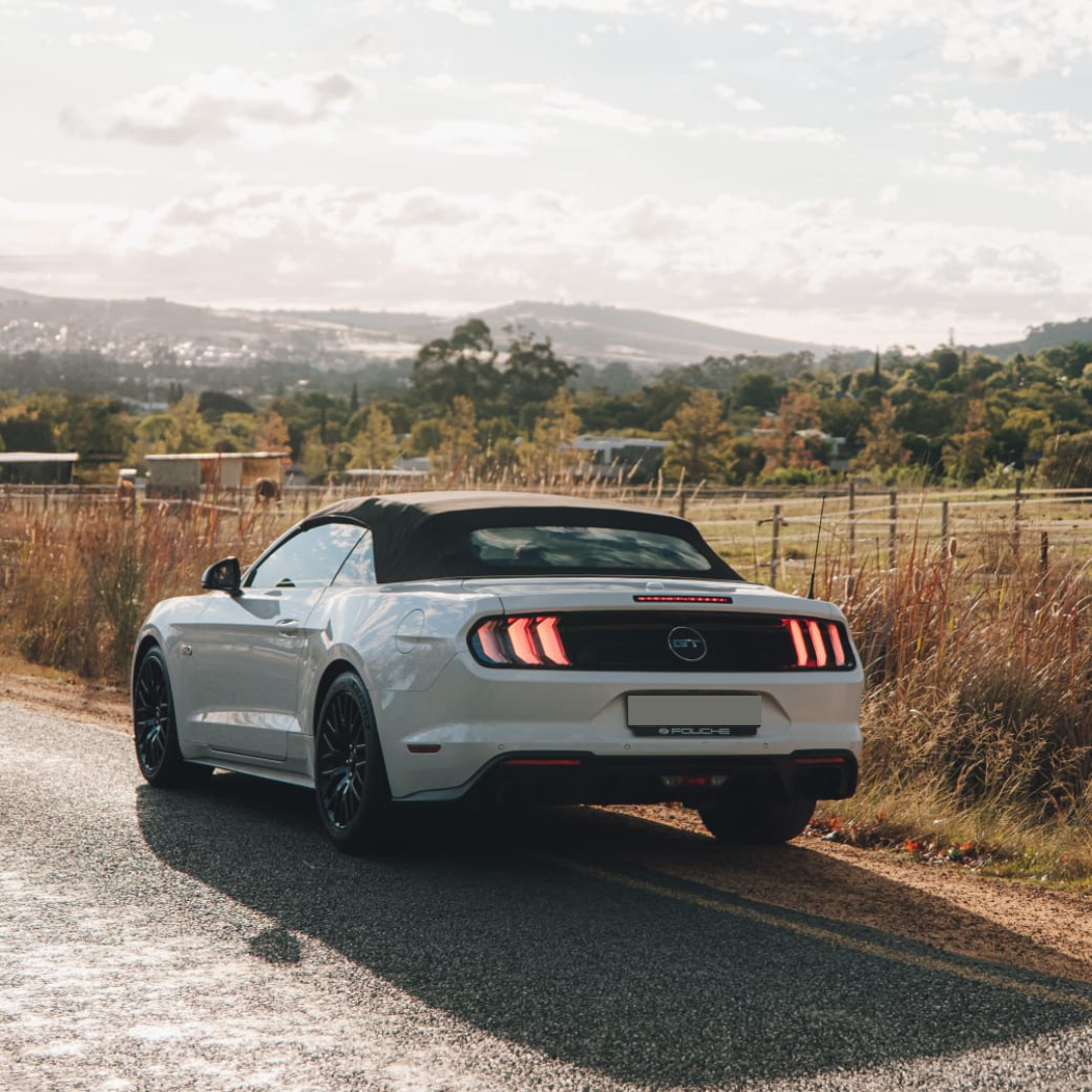 White Ford Mustang GT rear side angle on the road