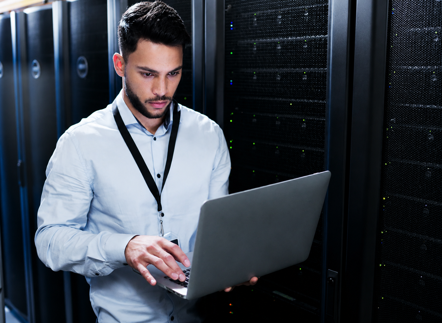 Employee working on a laptop in a server room