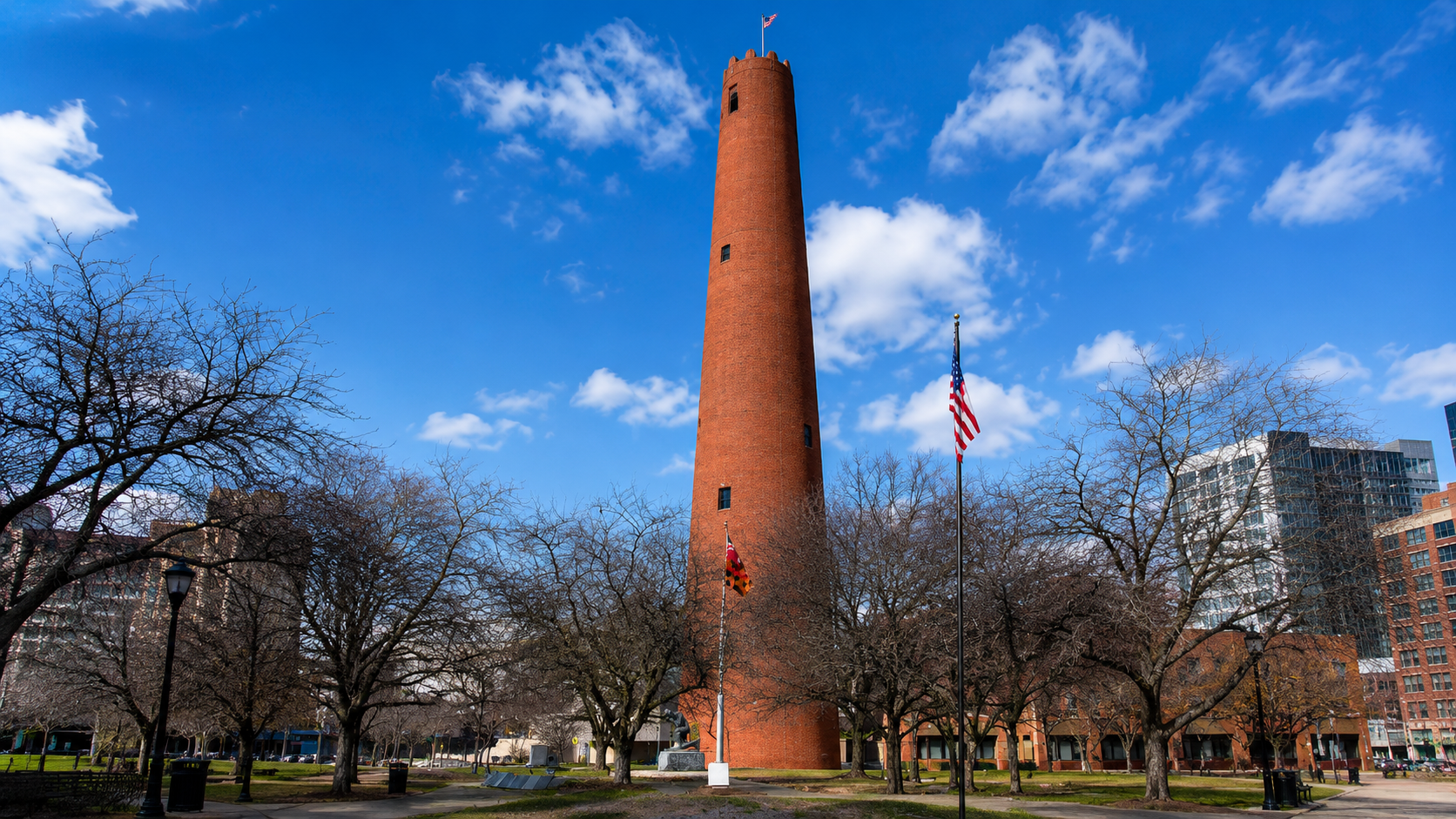 Phoenix Shot Tower in Baltimore Maryland rising above an urban park with historic red brick architecture