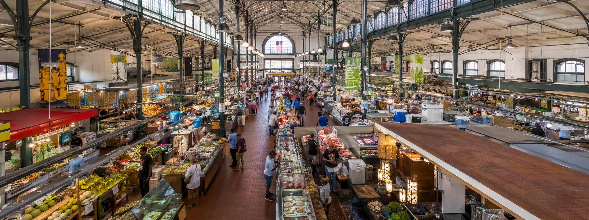 Historic Eastern Market interior in Baltimore with busy vendor stalls and local shoppers indoors