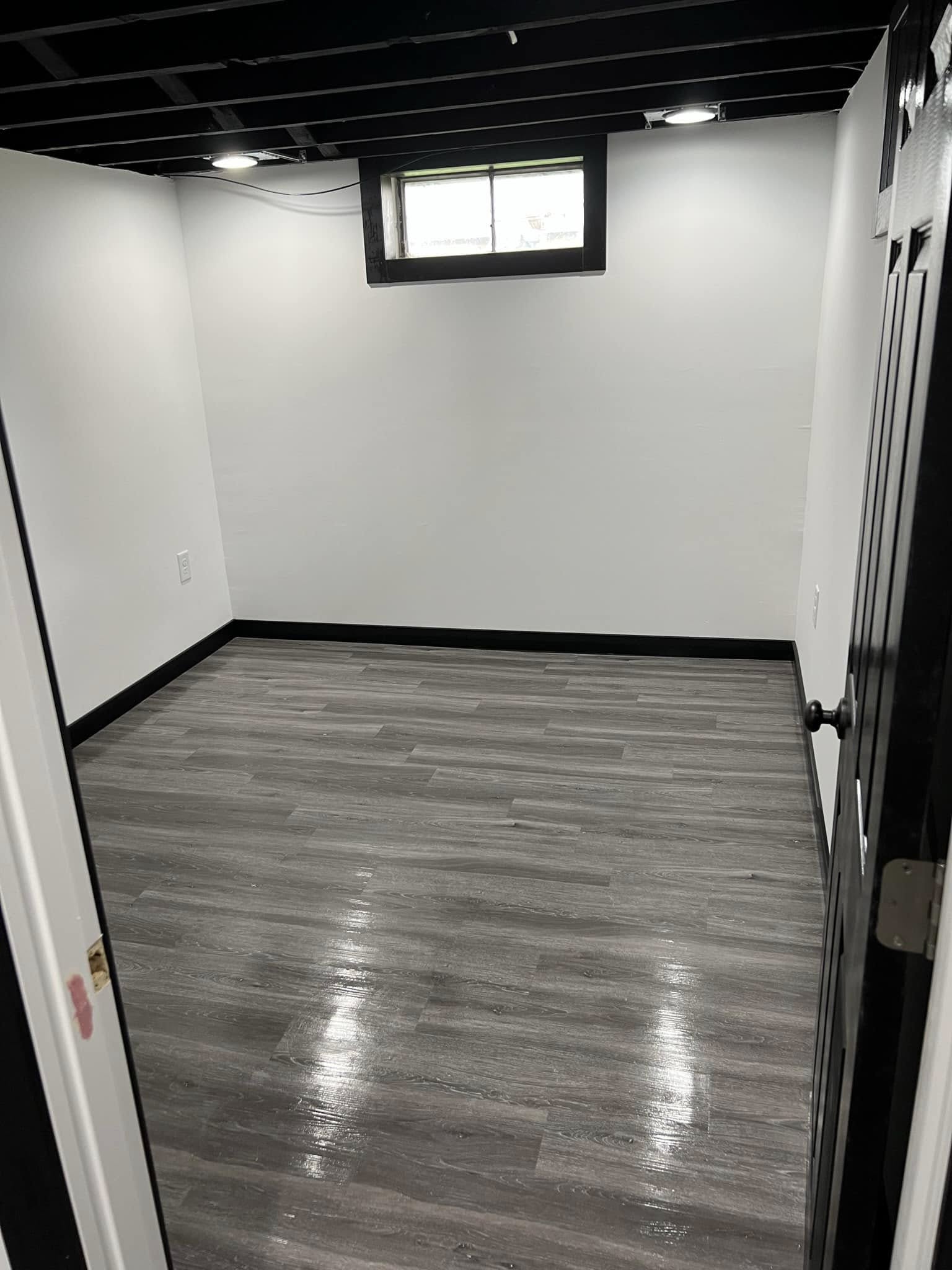 Finished basement room with an exposed ceiling in Bloomington, Illinois
