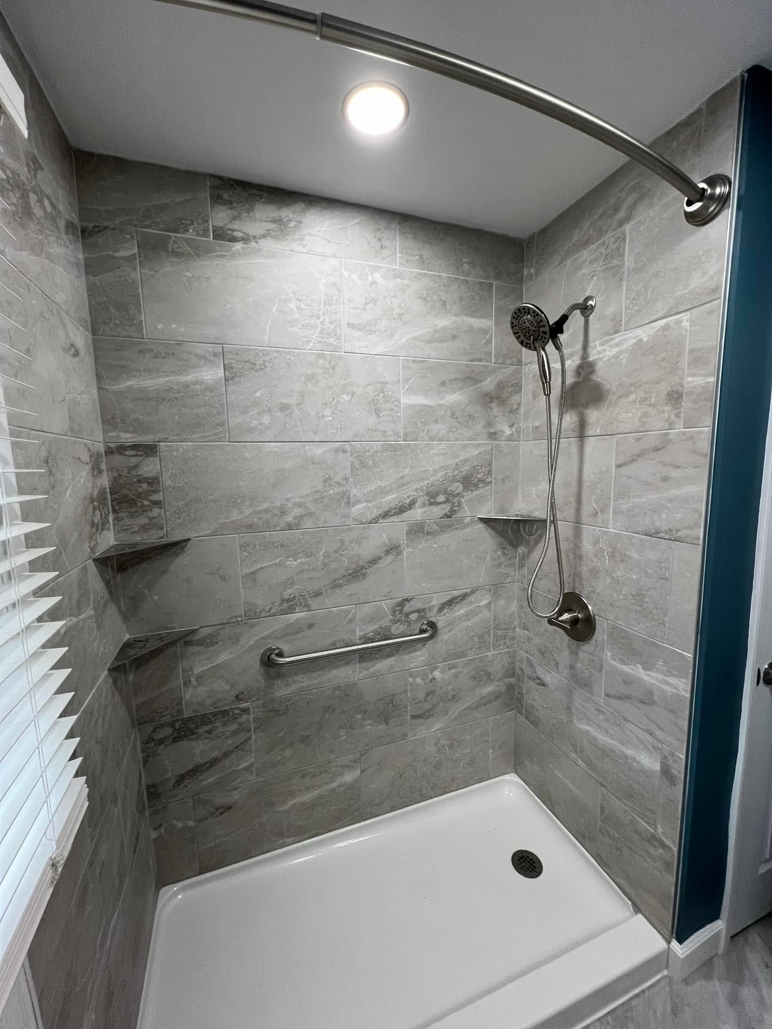 Accessible tile shower with a grab bar in a Bloomington, Illinois bathroom