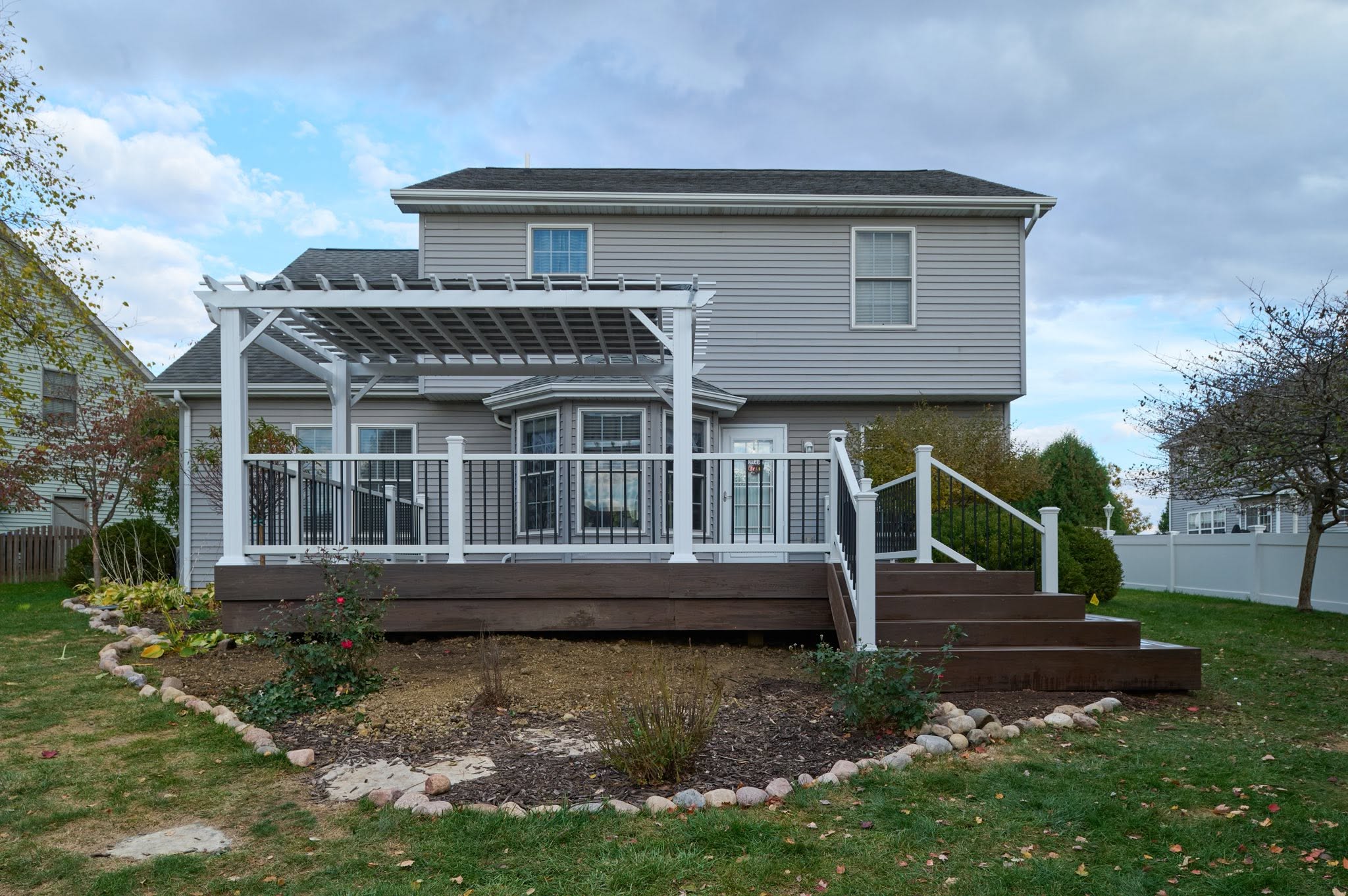 Composite deck with a white pergola built by Draper Construction Services in Bloomington, Illinois