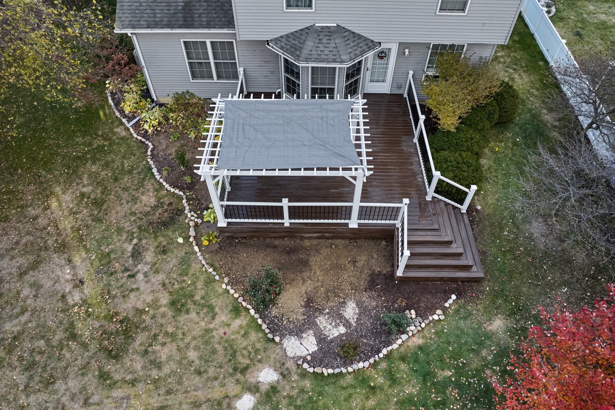 Composite deck with a white pergola viewed from above in Bloomington, Illinois