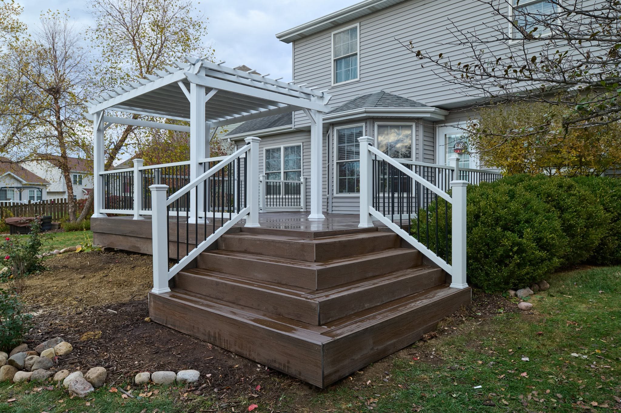 Composite deck with pergola and wide steps in Normal, Illinois