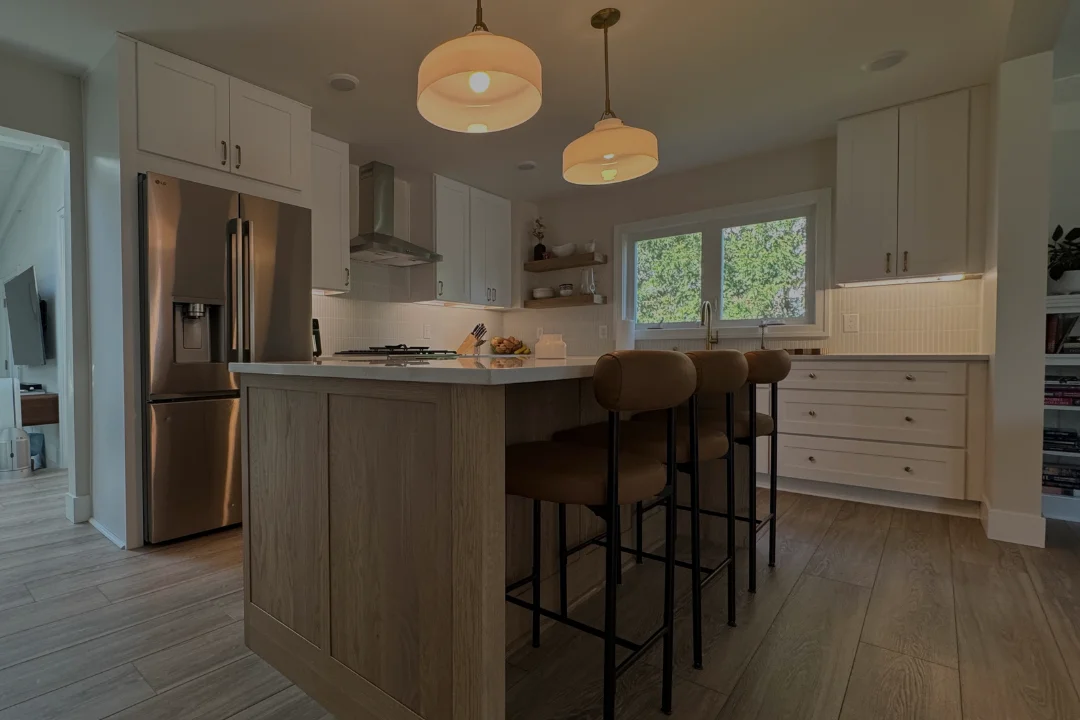 Remodeled kitchen in Grand Rapids, Michigan with white shaker cabinets, a white oak island and pendant lights by TPC Construction