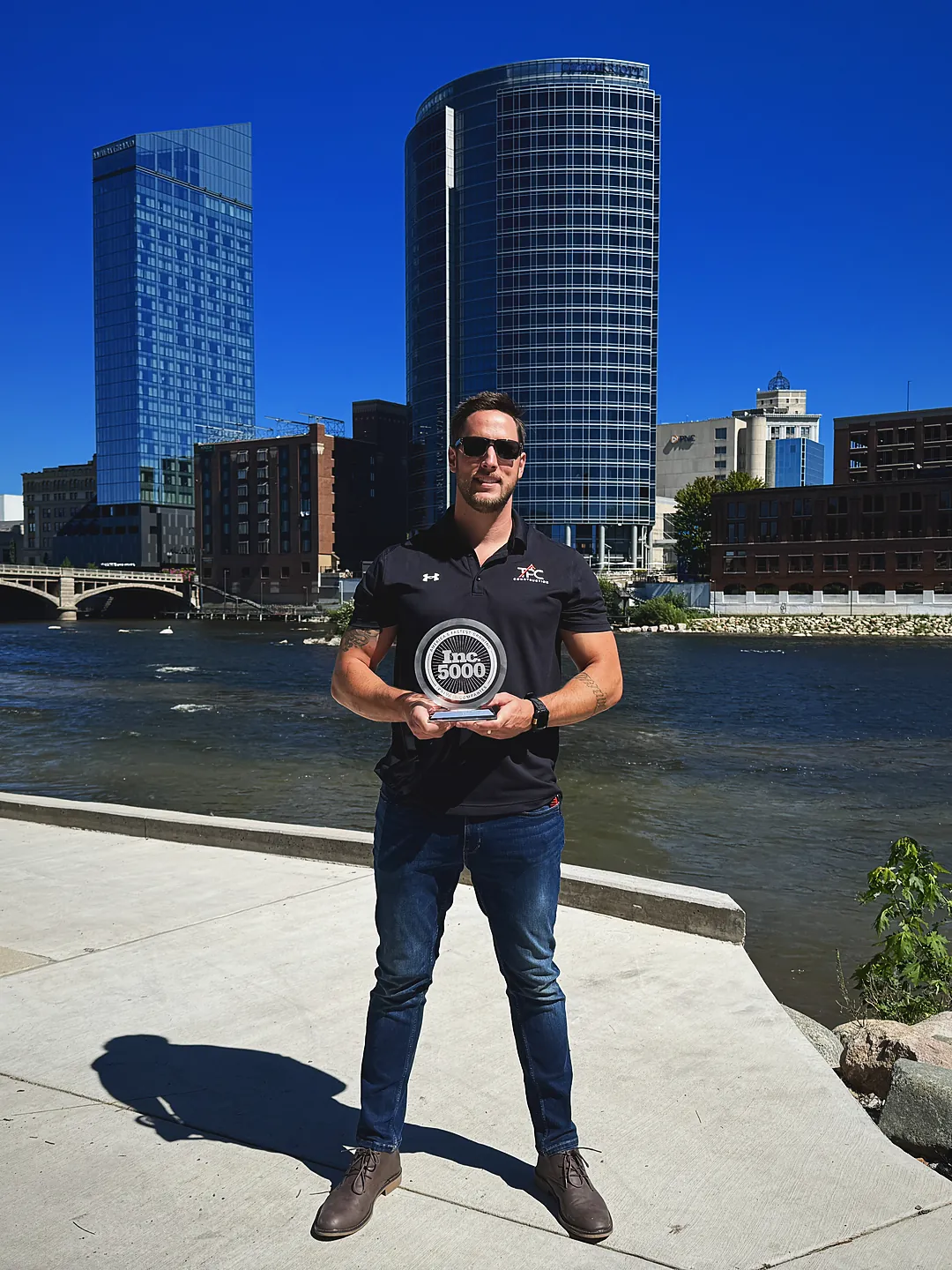 TPC Construction founder Ben Thaxton holding the company's 2026 Inc. 5000 award in Grand Rapids, Michigan