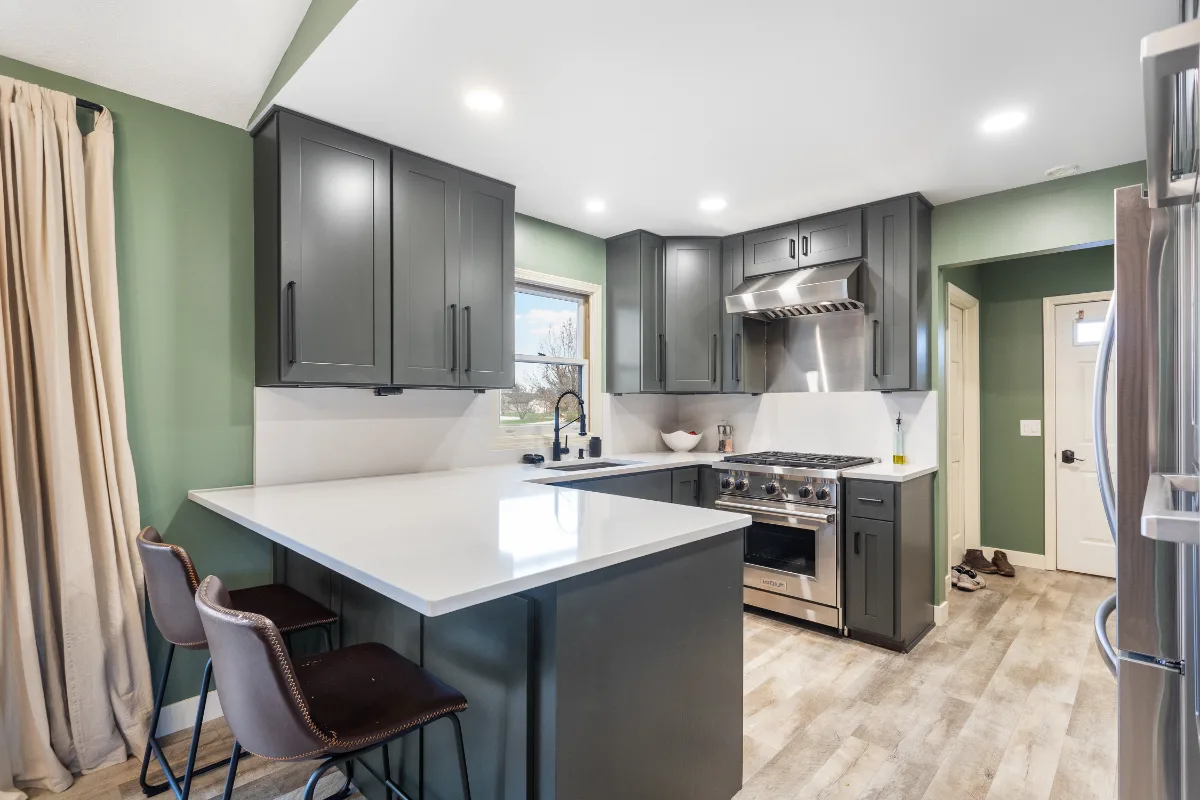Kitchen remodel in Grand Rapids, Michigan with gray shaker cabinets, a white quartz island and a stainless steel range