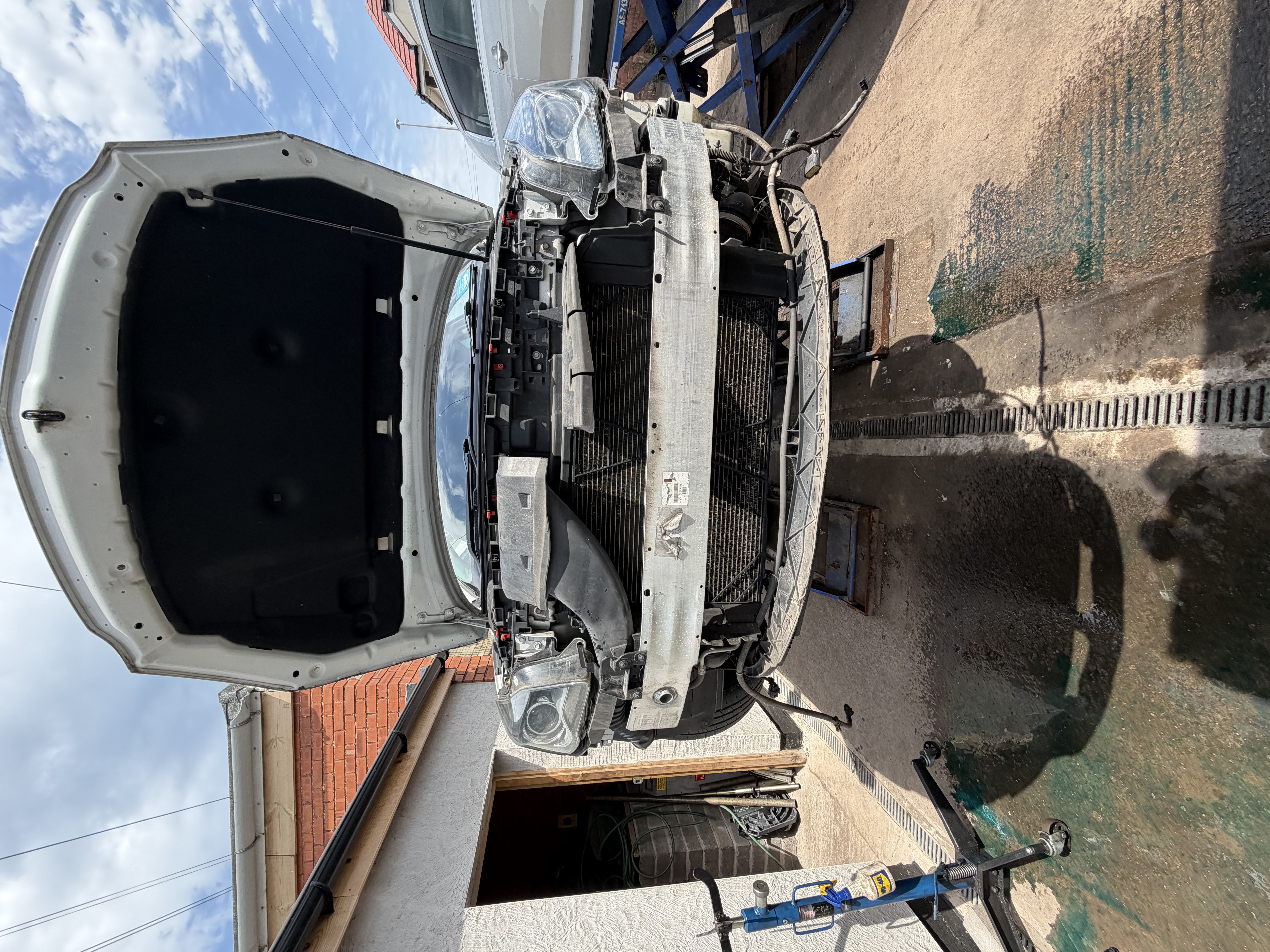 Vehicle with front bumper removed for cooling system access at Shaw's Service Station