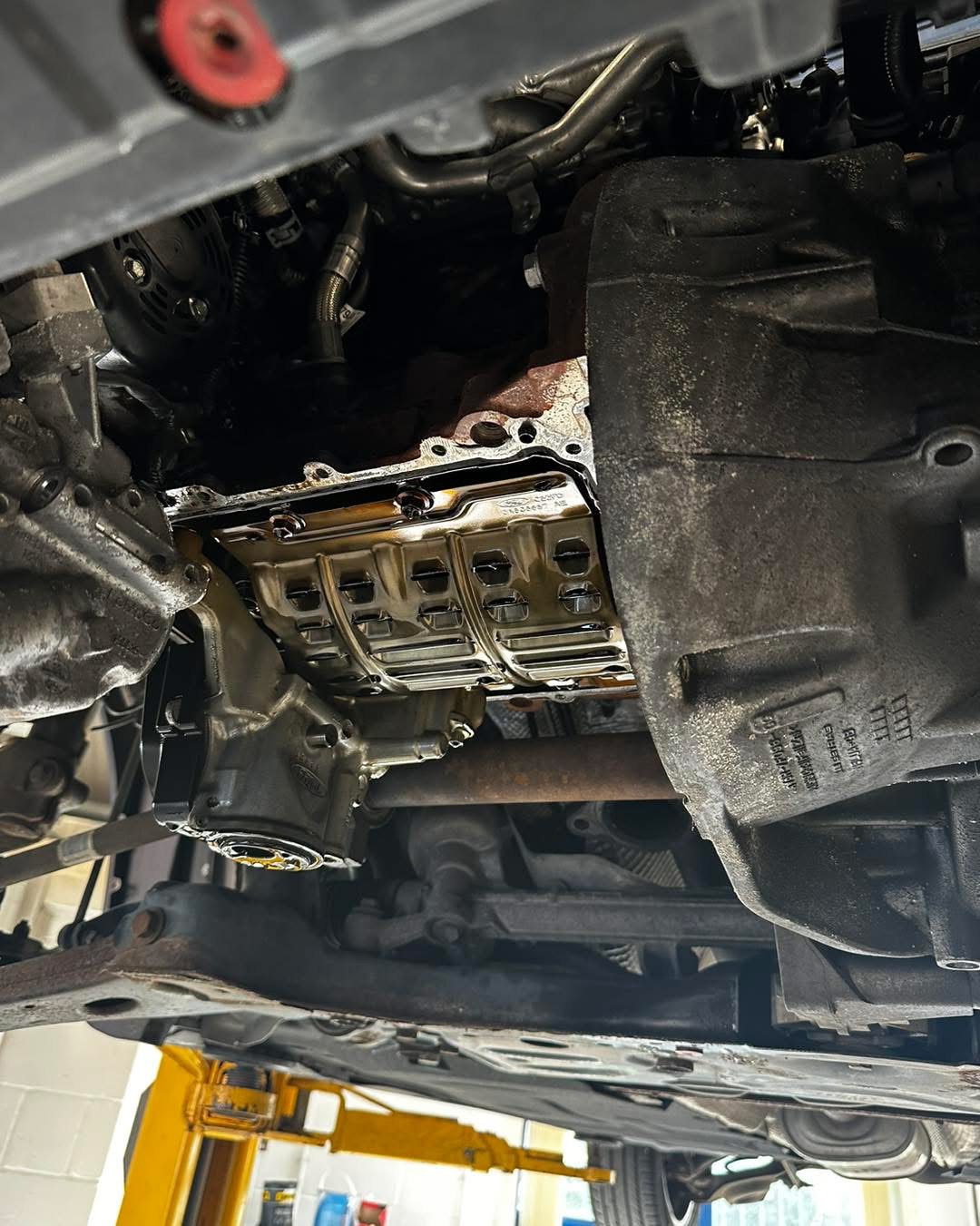 Underside of Ford 1.0 EcoBoost with sump removed exposing oil pump pickup area at Shaw's Service Station Rhyl