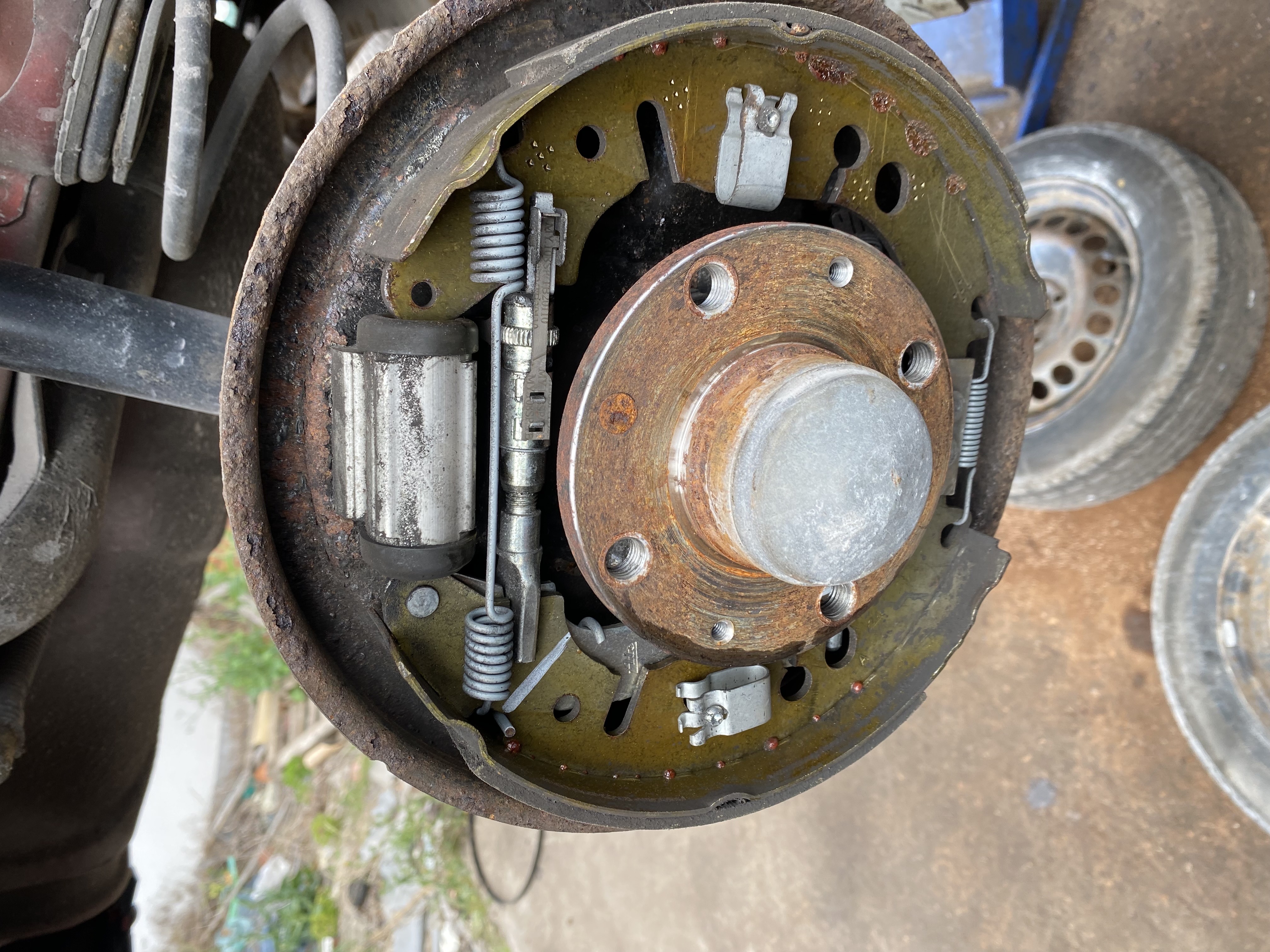 Rear drum brake assembly with the drum removed, showing brake shoes, wheel cylinder and retaining springs at Shaw's Service Station