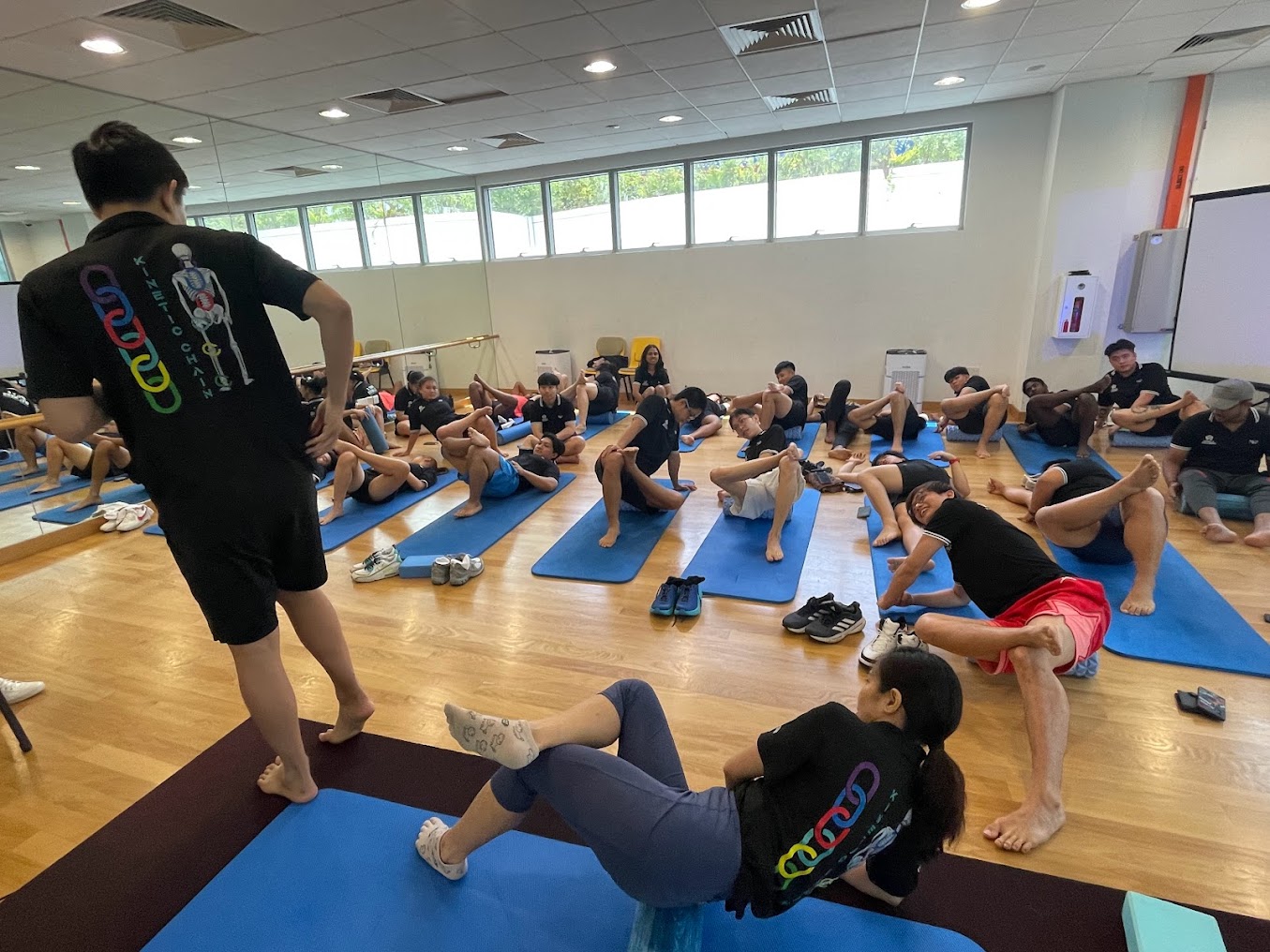 BloomQueen Pain Relief Specialist instructor leading a mat-based mobility class.