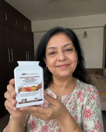 A woman holding a bottle of BloomQueen Ashwagandha at home