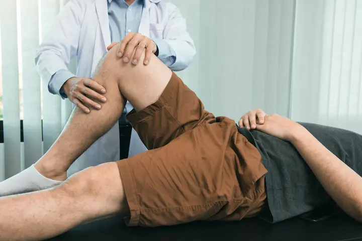Clinical image of a chiropractor performing a joint mobility evaluation on a patient's knee