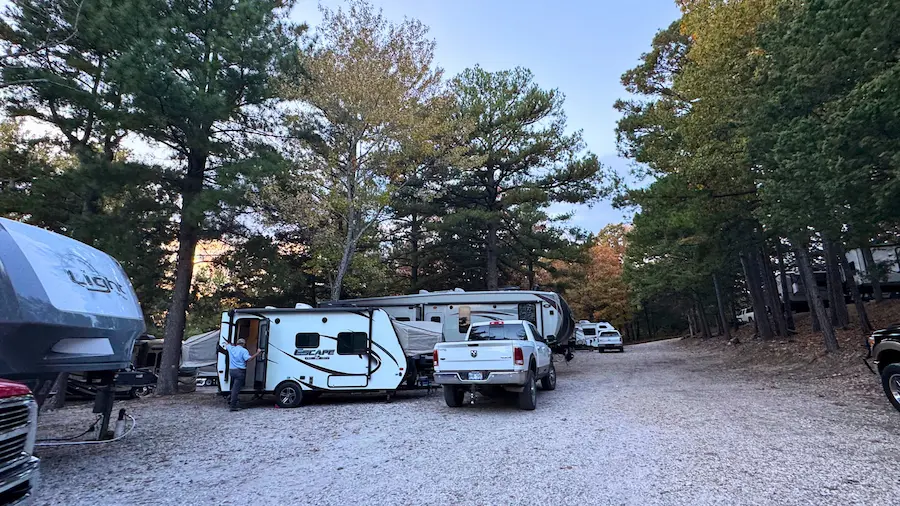 Level, wooded long-term RV pad surrounded by trees at Ozark RV Park