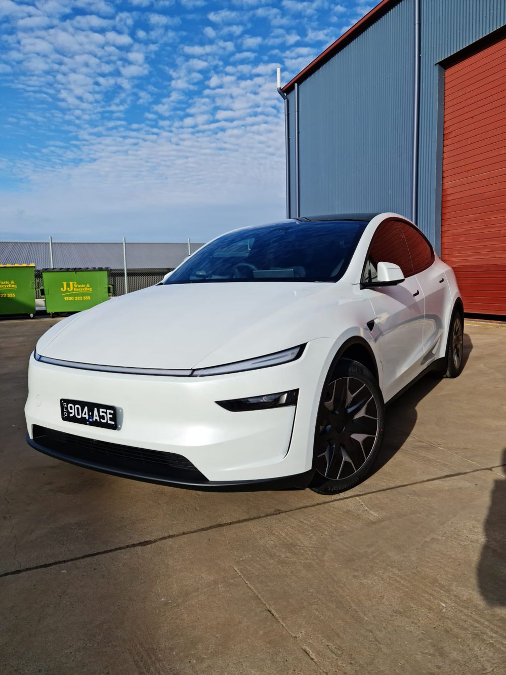 White Tesla Model Y with tinted windows outside the Apex Auto Lab workshop