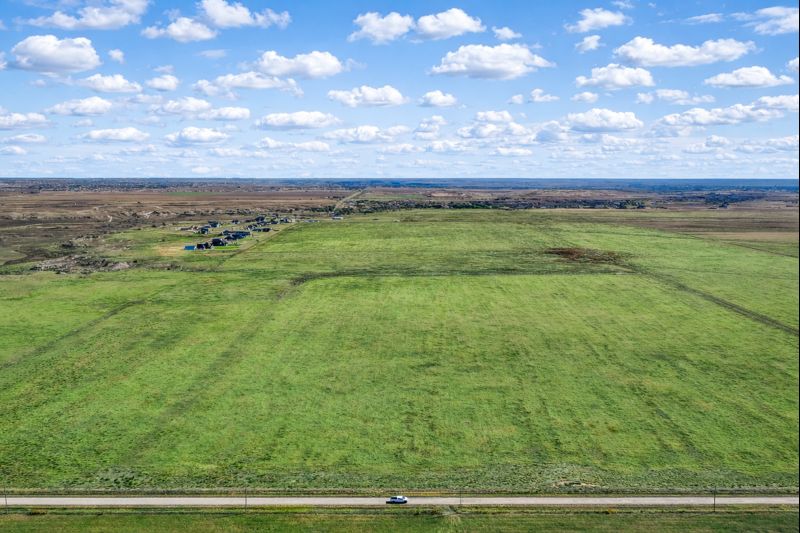 Aerial view of a wide green field under a blue sky on 10-acre land near Canyon, Texas