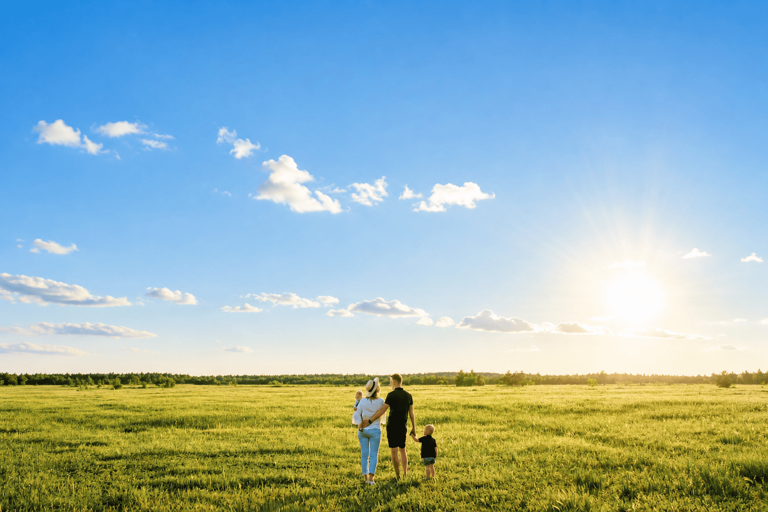 A family standing on open Texas land at sunset
