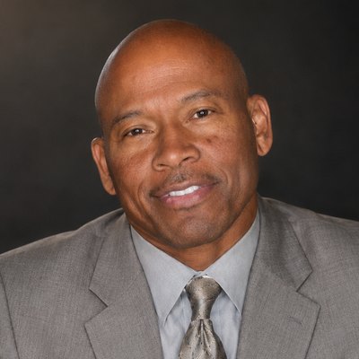 Bill Saulsberry, founder of Mustard Seed Personal Car Service, in a grey suit and patterned tie.