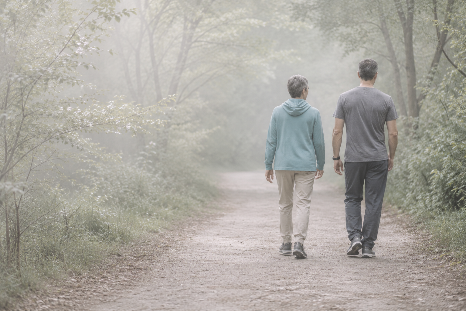 A couple walking together through a misty forest path