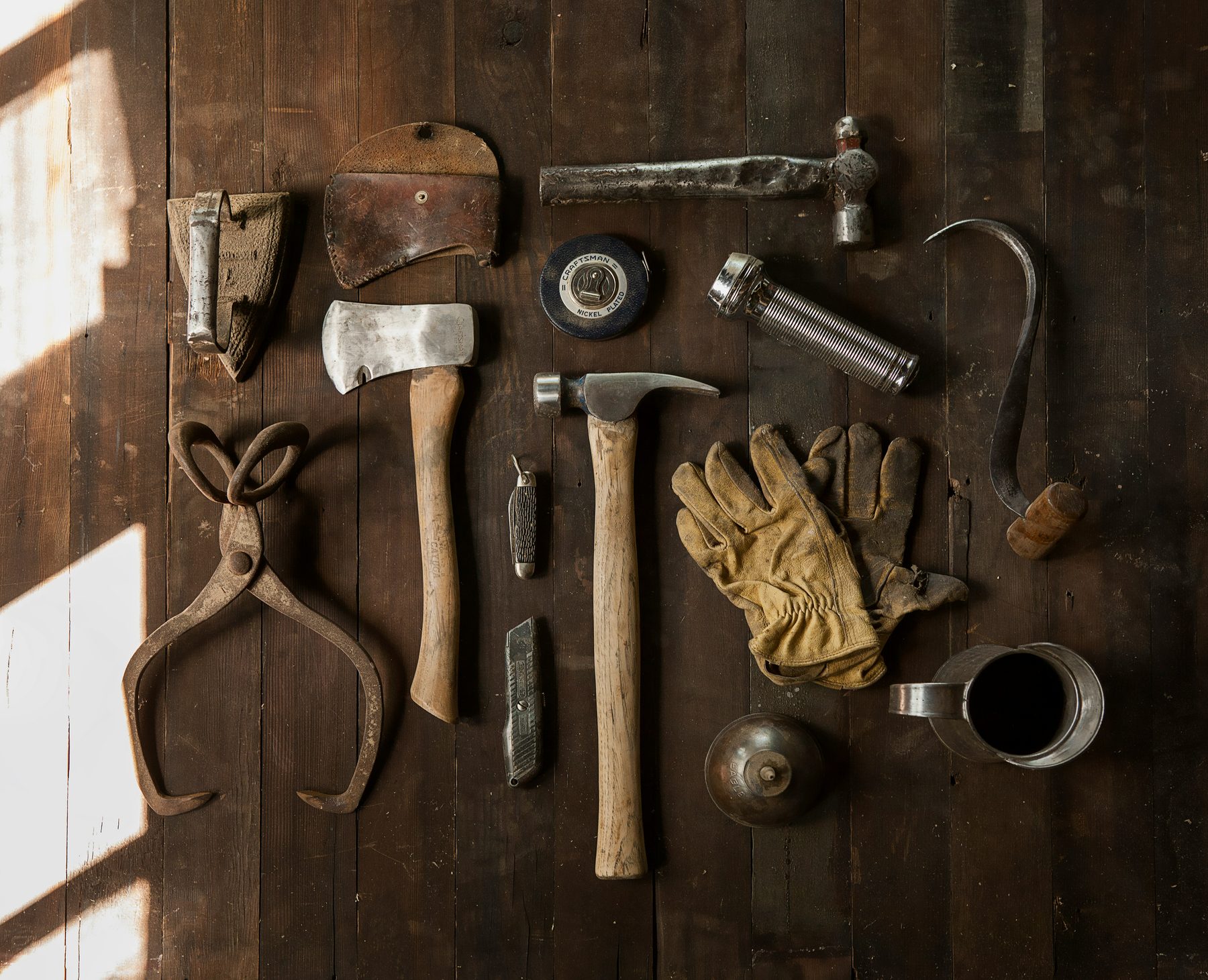 Real estate tools — a tape measure, ratchet and socket set and reciprocating saw spread out on a workbench
