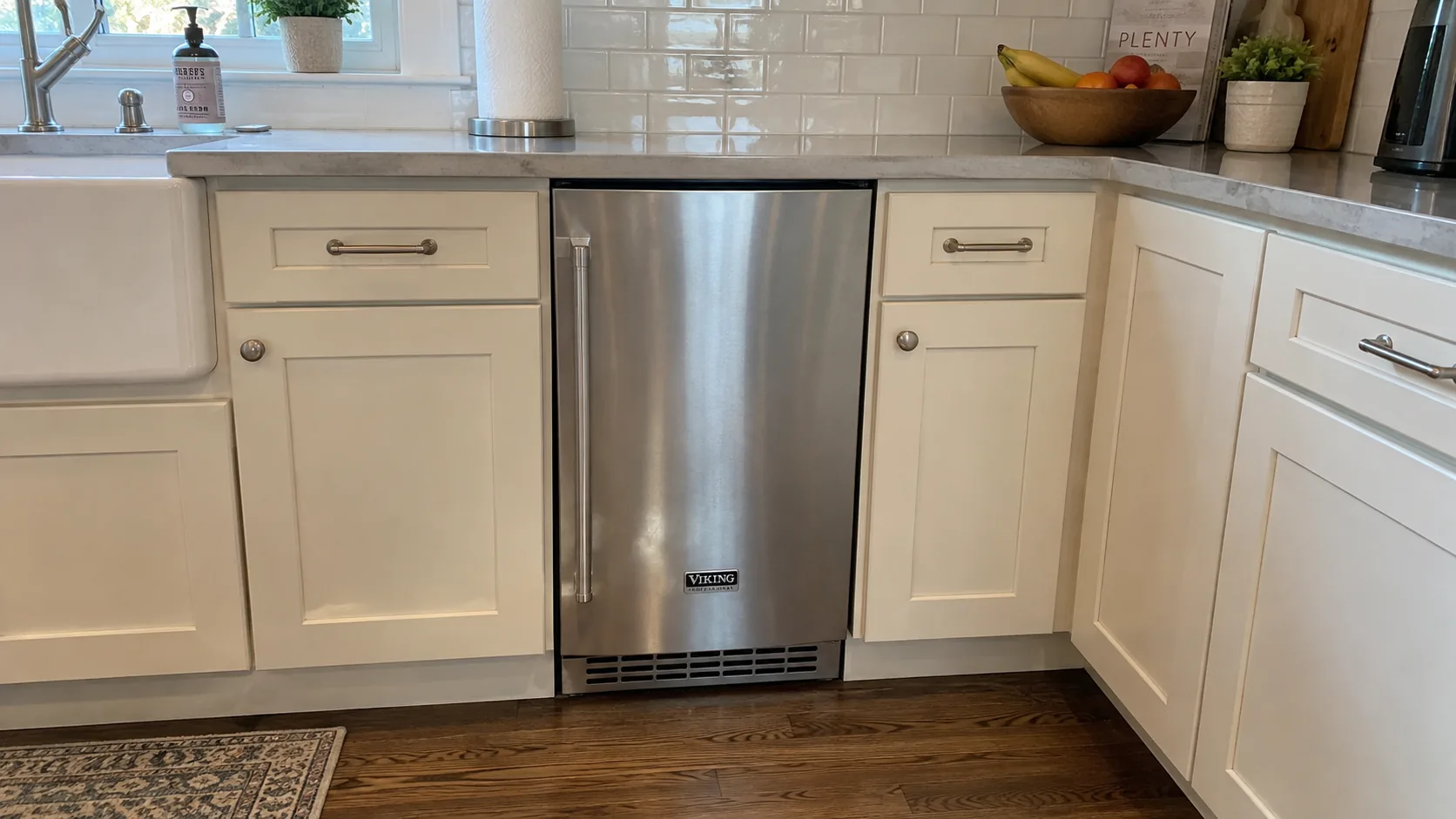 Closed stainless Viking undercounter ice maker in a kitchen
