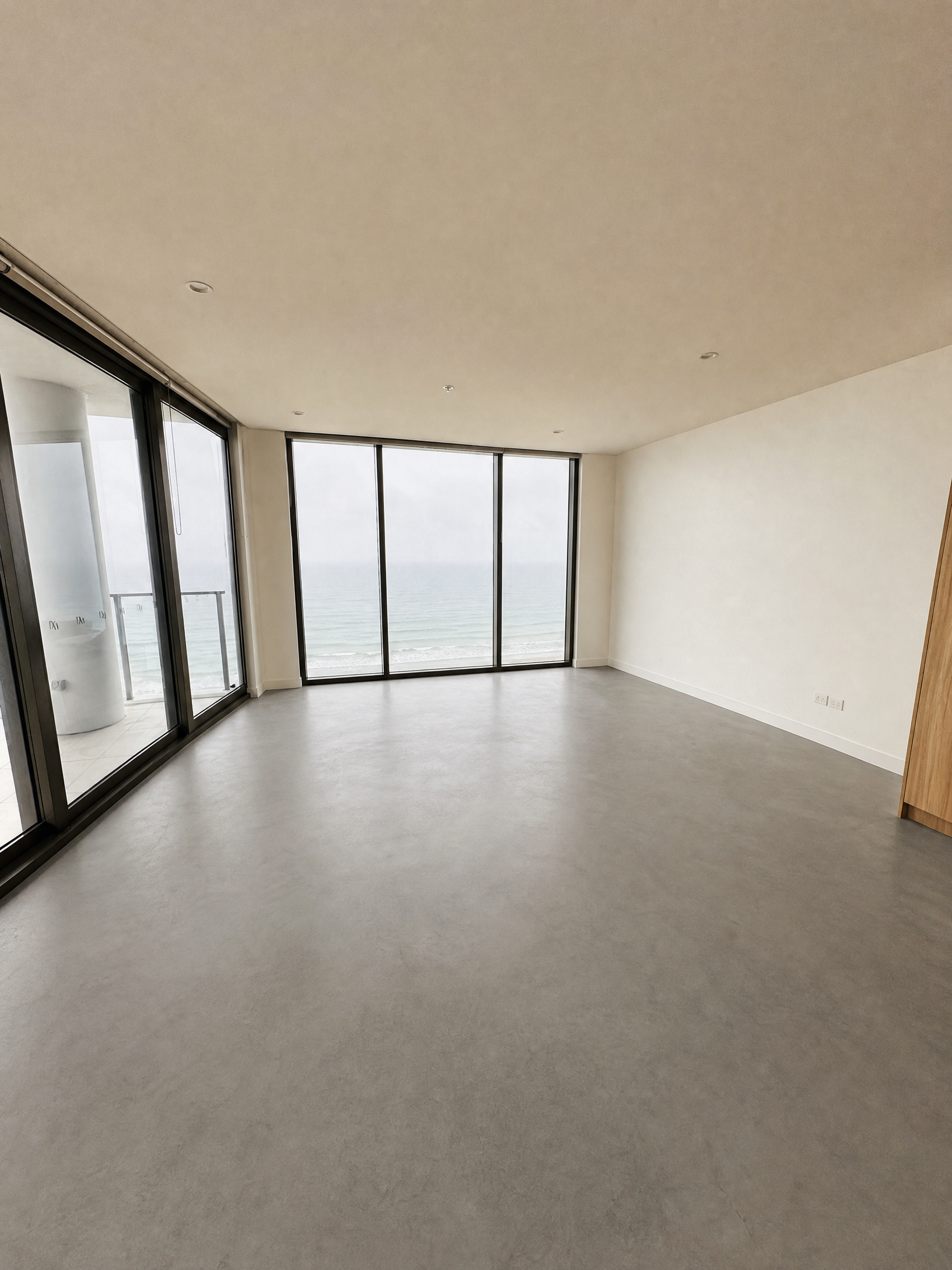Burleigh apartment before flooring, bare concrete with ocean view