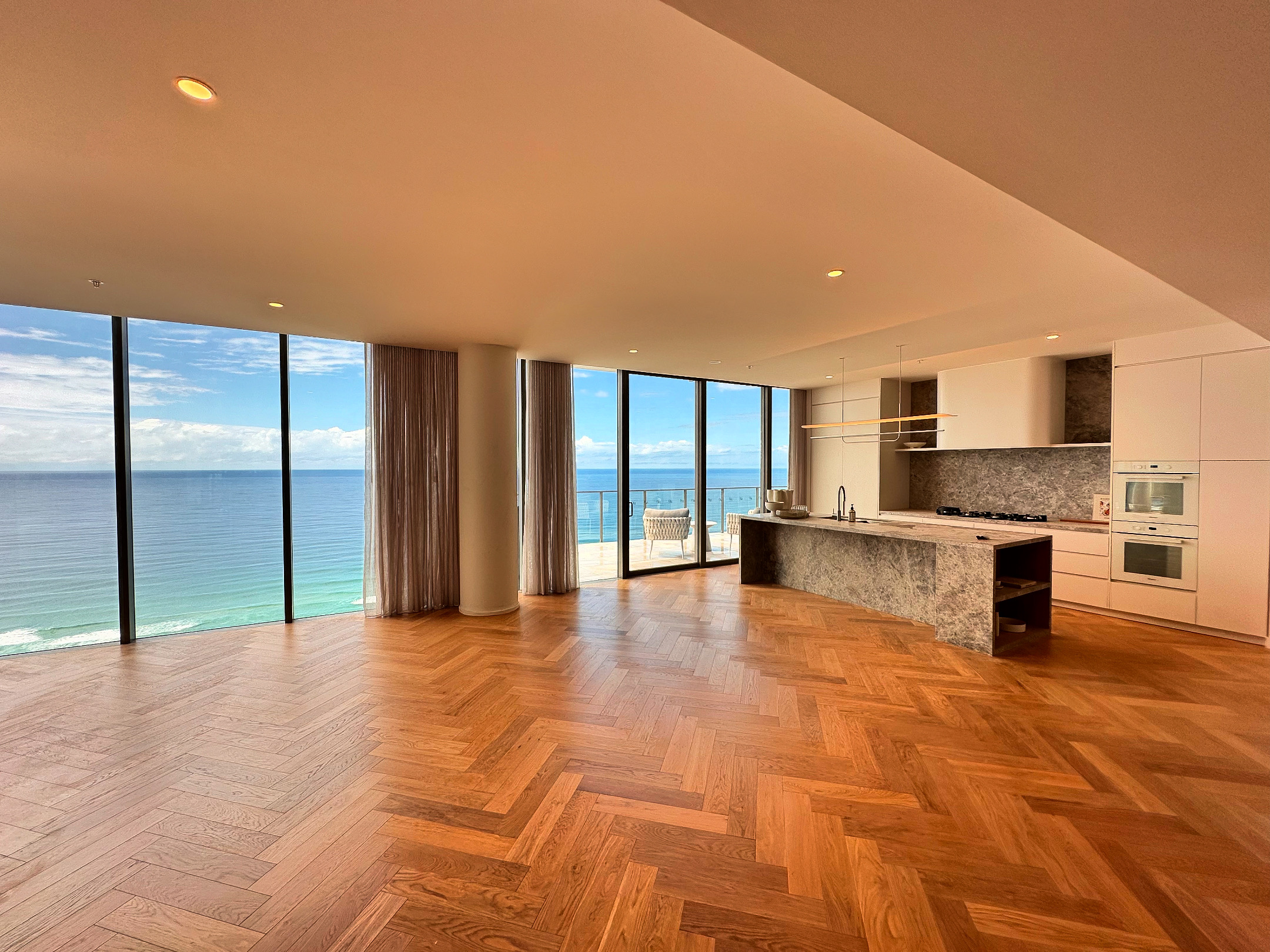 Finished herringbone timber floor in a Gold Coast living room and kitchen with ocean views