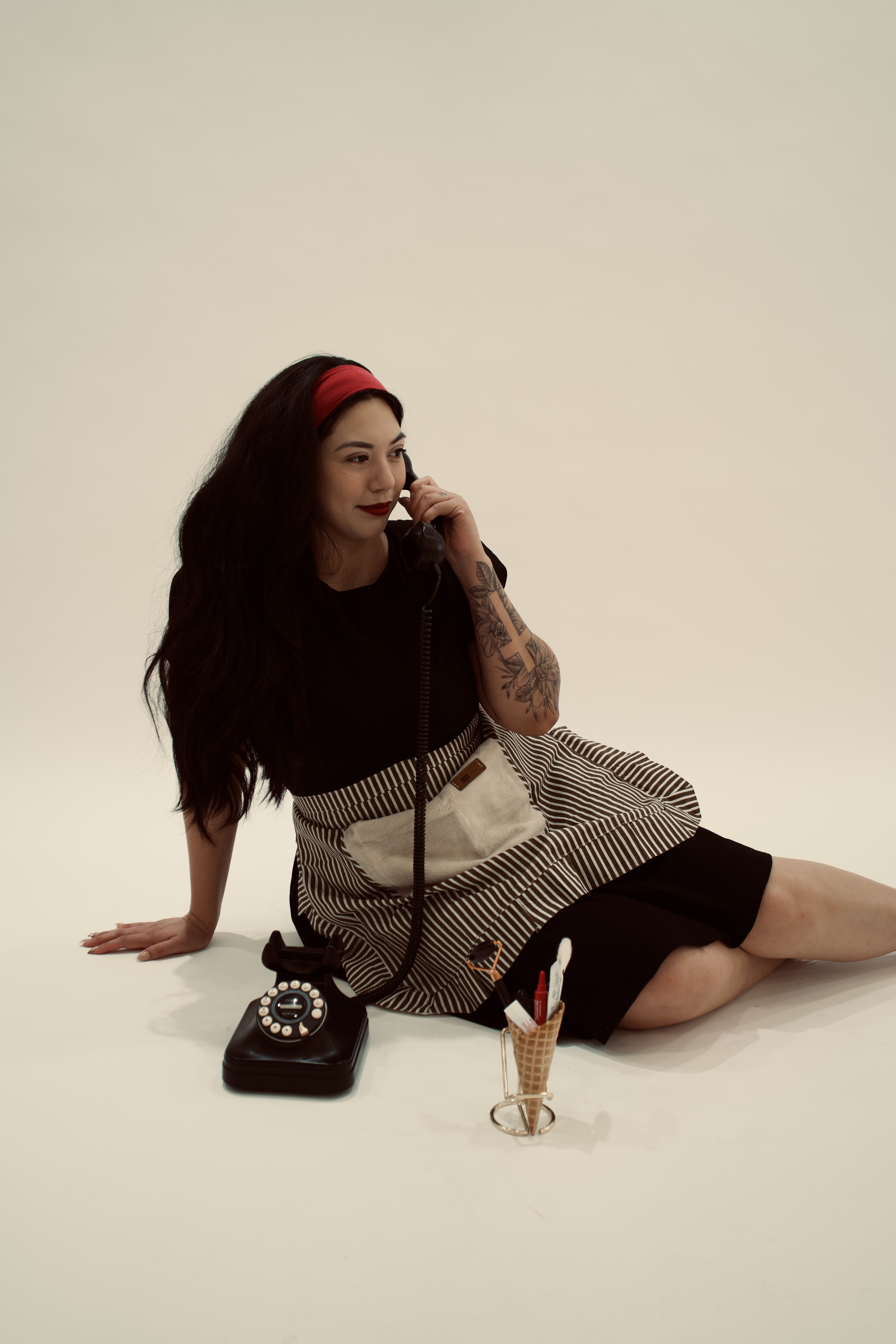Bianca seated while speaking on a vintage phone
