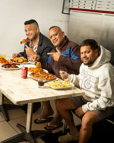 Workmates sharing pizza and pasta around a table