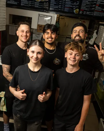 A team of staff giving thumbs up together