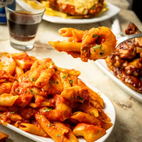 Penne pasta in napoli sauce with a fork
