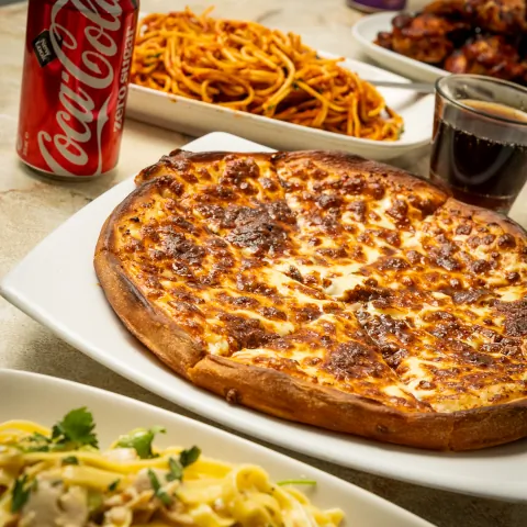 Catering spread of pizza, spaghetti and chicken wings on a table