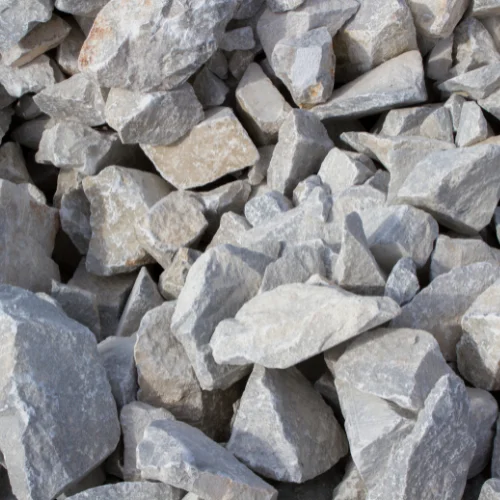 Une prise de vue en plein cadre de pierres concassées de formes irrégulières, de couleur gris clair et blanc cassé, avec quelques ombres.