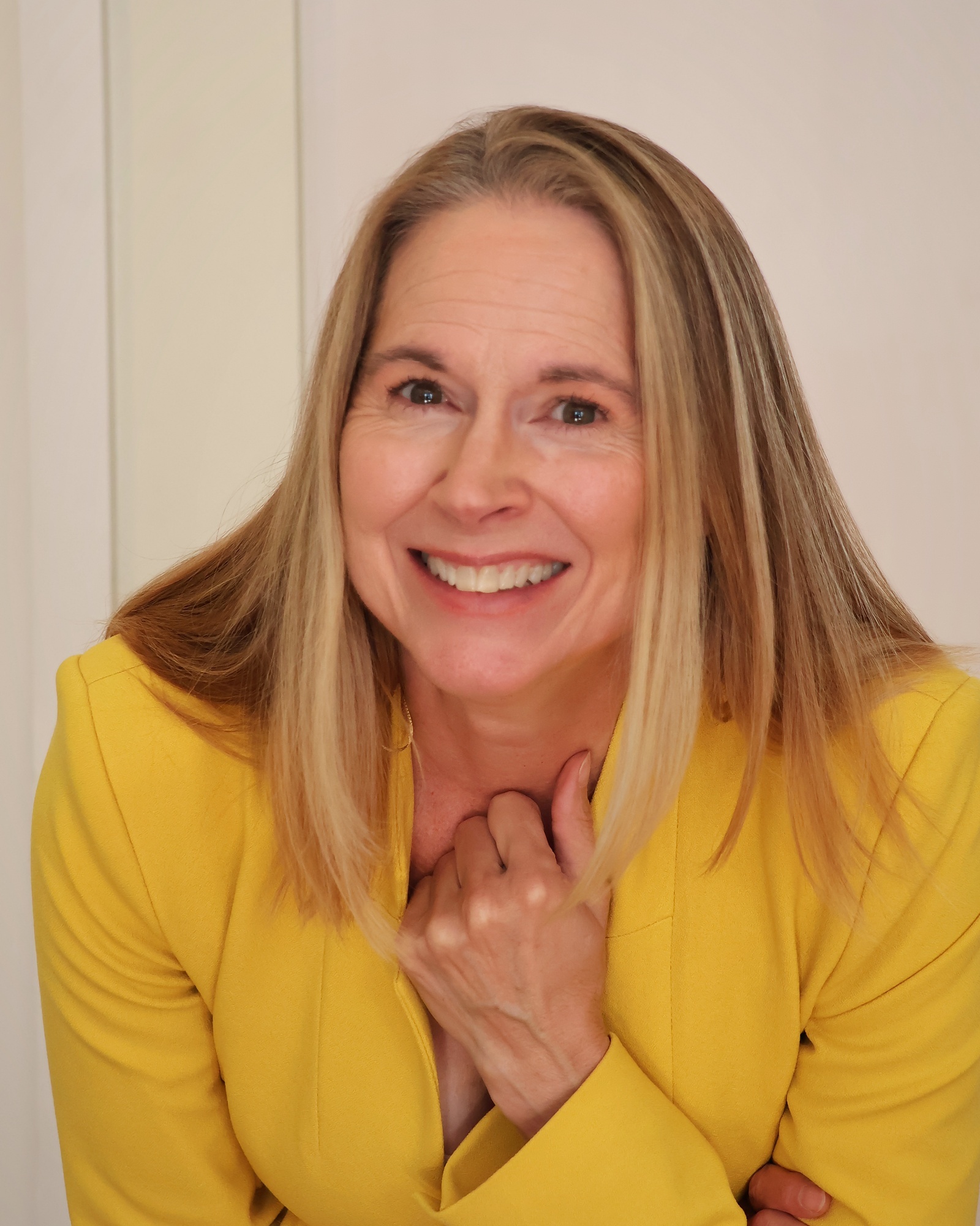 Diana Brittain Thompson smiling in a yellow blazer
