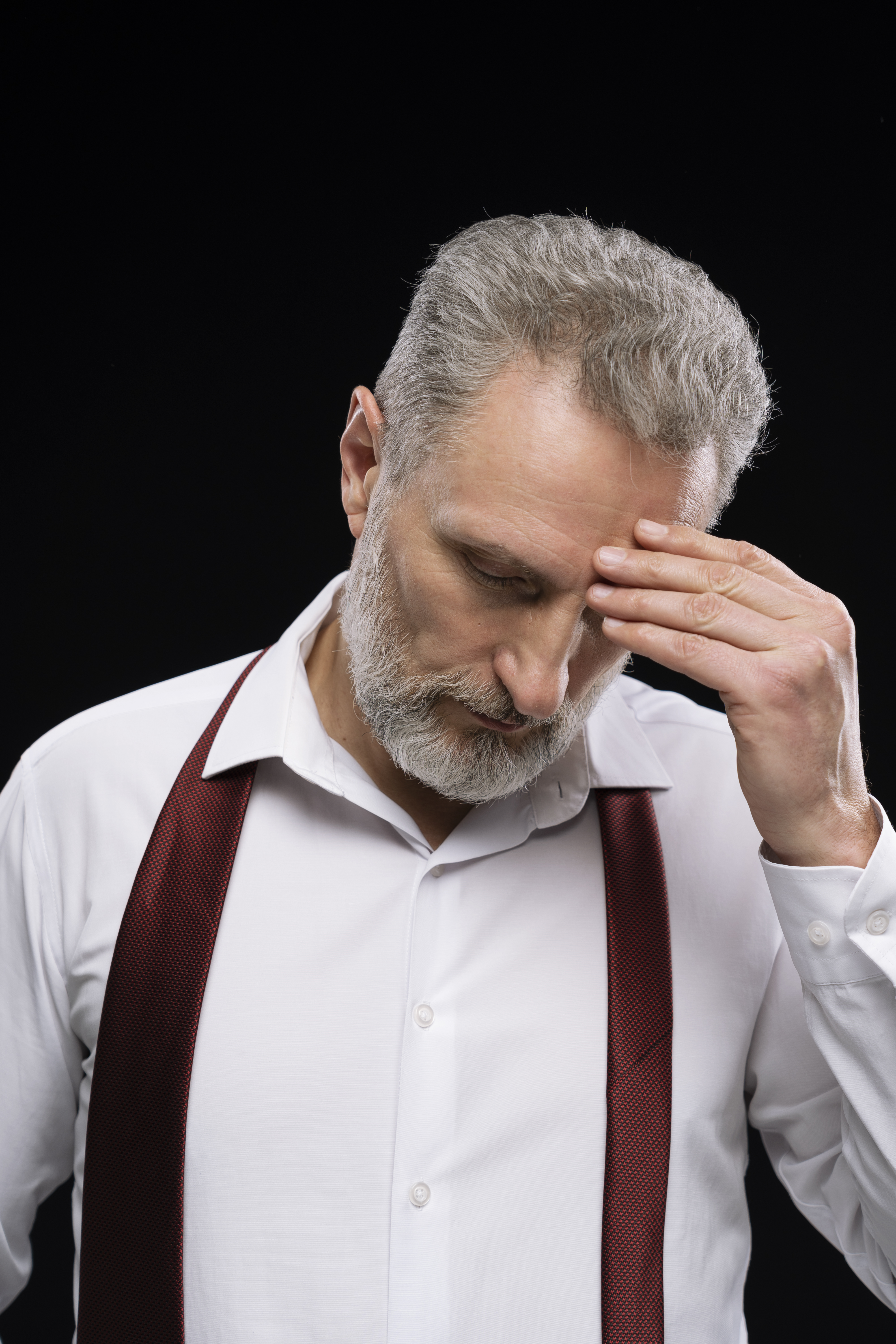 Pensive businessman working at a computer, reflecting fatigue and misalignment
