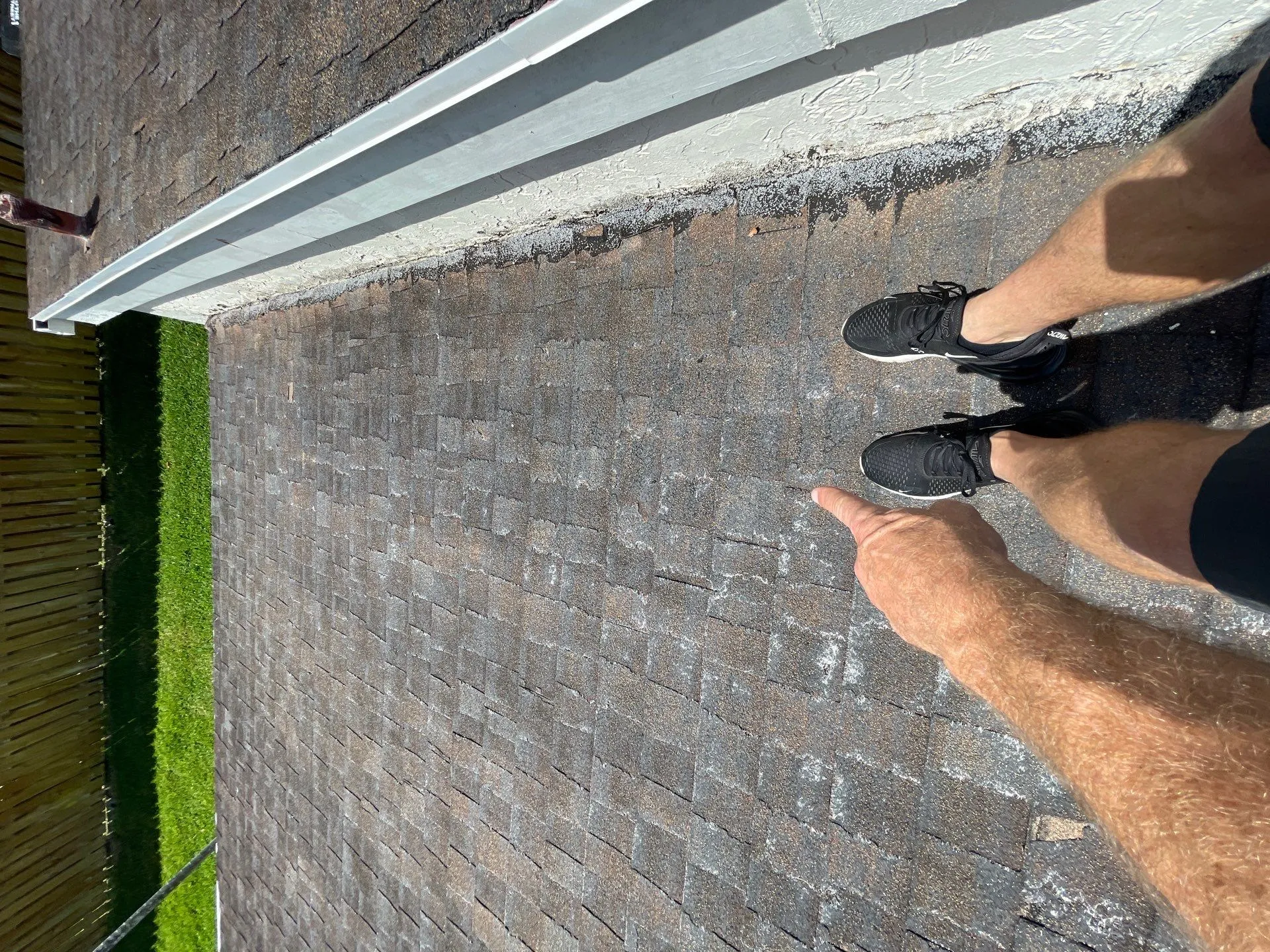 Storm-damaged shingle roof before replacement