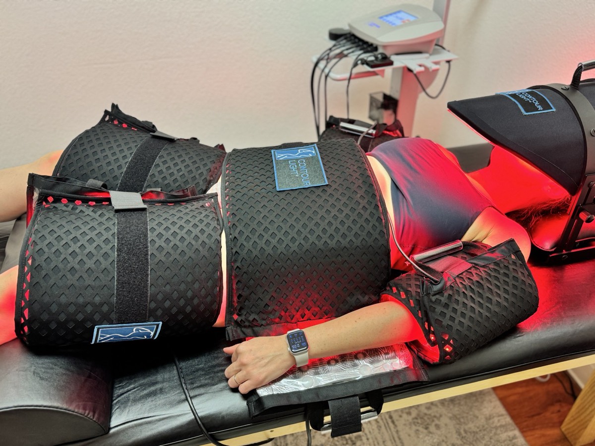Client relaxing under Contour Light red light pads at Genesis Red Light in Cedar Park, TX
