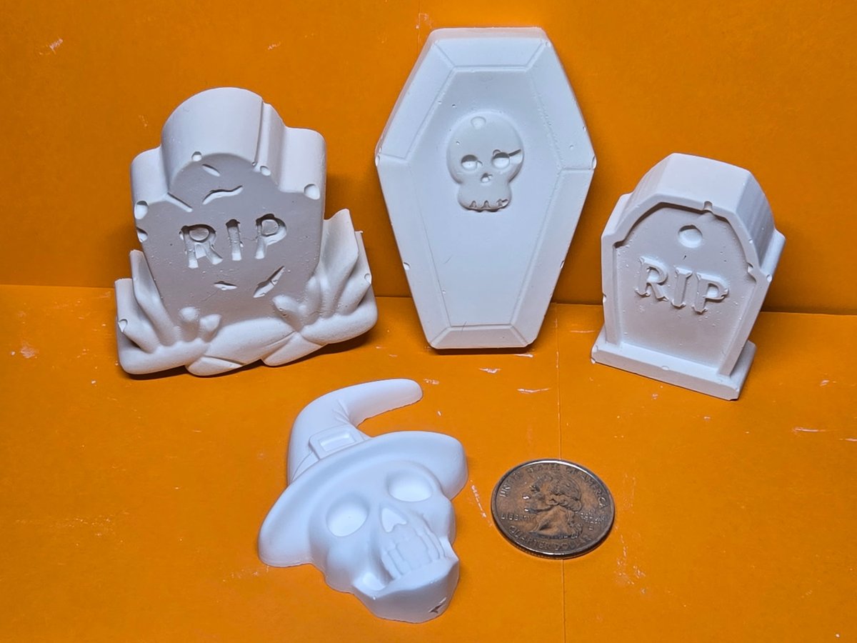 Unpainted plaster tombstones, a coffin and a skull in a witch hat
