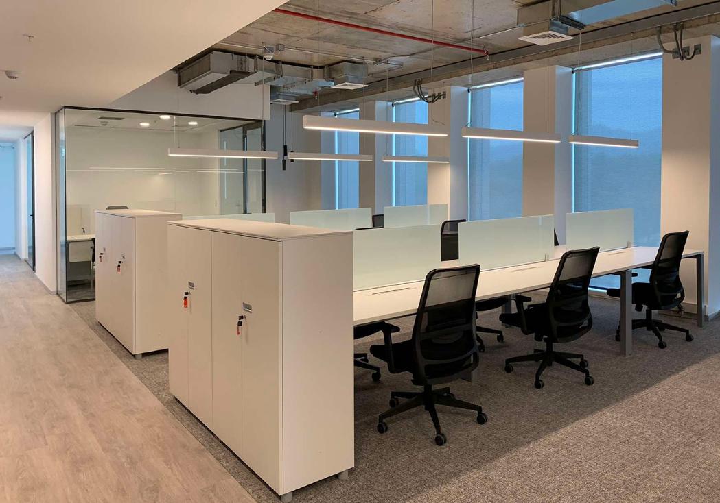 Oficinas de Isotron Chile en Torre Santa María, Providencia, con estaciones de trabajo y tabiques vidriados